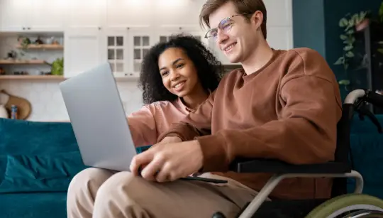 man on wheelchair using laptop